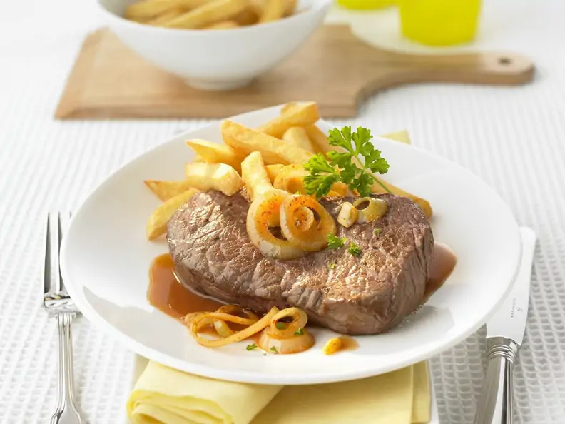 Rindersteak mit Bier-Zwiebel-Soße und Pommes frites