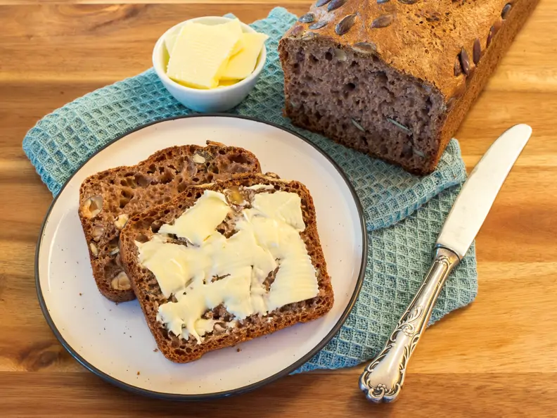 Dinkelvollkornbrot: aufgeschnitten und mit Butter bestrichen