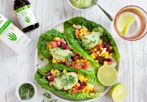 Salat-Tacos gefüllt mit Bohnen, Mais, Tomaten und Avocado-Omega-3-Dip
