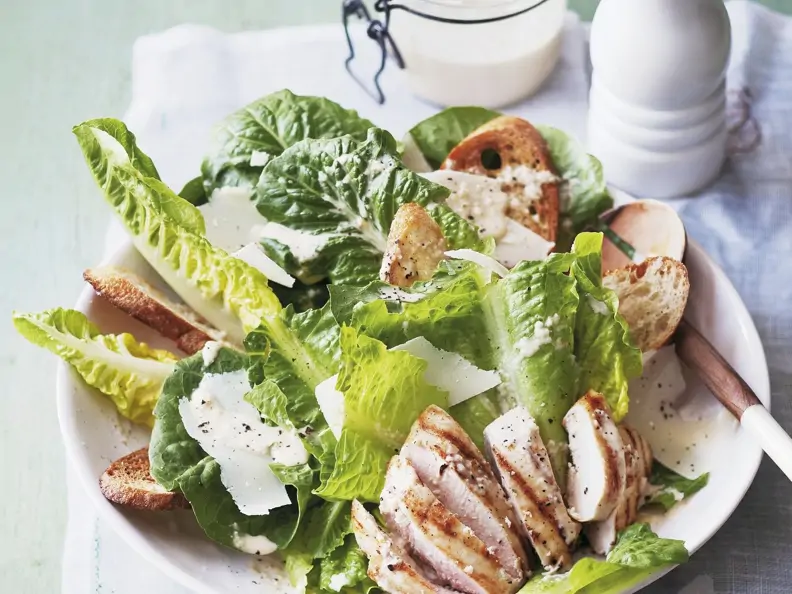 Römersalat mit Hähnchenbrust auf einem weißen Teller
