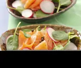 Salat mit Spinat, geräuchertem Lachs, Radieschen und Pfefferkörnern