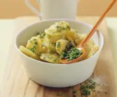 Kartoffelsalat in weißem Schälchen