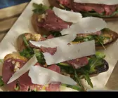 Röstbrot mit Carpaccio, Rucola, Avocado und Parmesan