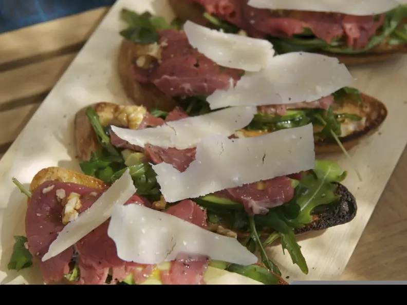Röstbrot mit Carpaccio, Rucola, Avocado und Parmesan