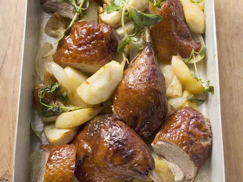 Stücke vom Entenbraten mit Apfel, Zwiebeln und Kräutern