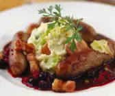 Bratwurst mit Kartoffelbrei, Speck und Blaubeersoße