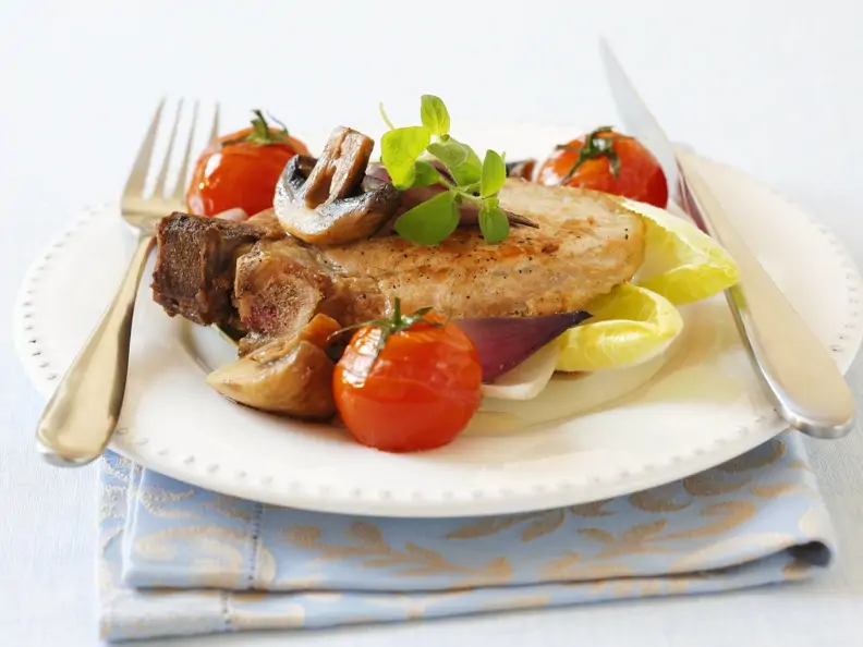 Kotelett mit Champignons, Zwiebeln und Tomaten
