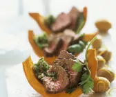 Kürbisspalten mit Pesto und Rückenbraten (Rumpsteak) und karamellisierten Kartoffeln