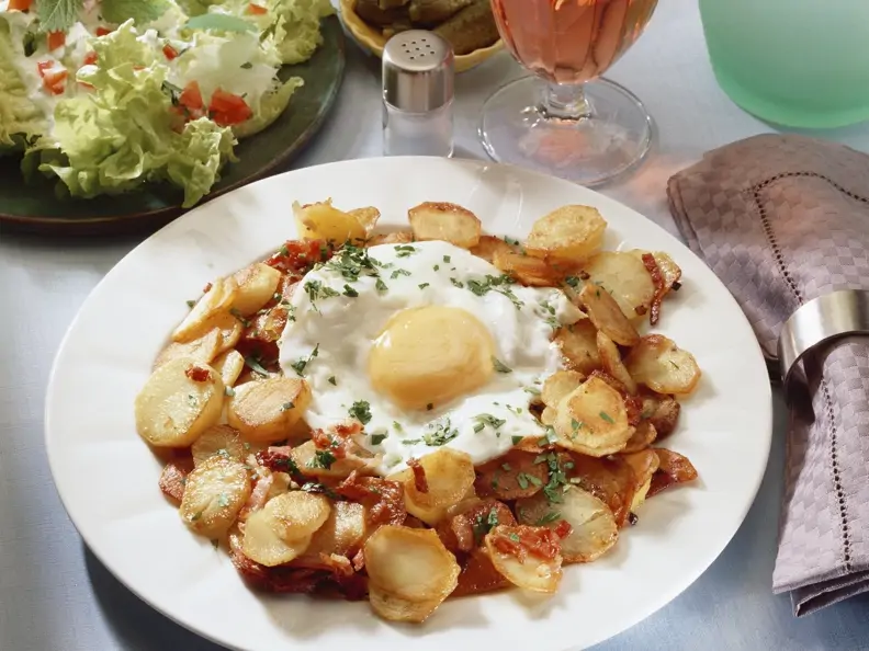 Gebratene Kartoffeln mit Spiegelei und grünem Salat