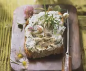 Rustikales Brot mit Kräuterbutter und Gänseblümchen