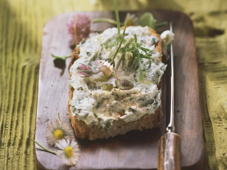 Rustikales Brot mit Kräuterbutter und Gänseblümchen
