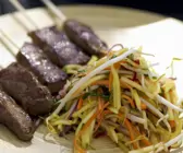 Fleischspieß mit Salat aus Mango
