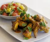 Knusprige Hähnchenteile und bunter Tomatensalat