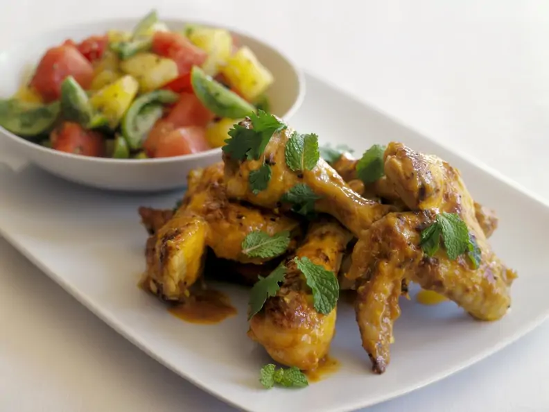Knusprige Hähnchenteile und bunter Tomatensalat