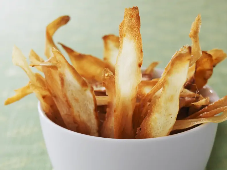 goldgelbe Pastinaken-Chips in weißer Schale