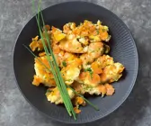 Möhren-Kardamom-Schmarrn mit Gruyère in dunklem tiefem Teller