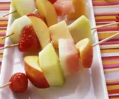 Obstspieße auf weißem Teller