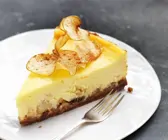 Apfel-Käsekuchen mit Keksboden auf grauem Grund
