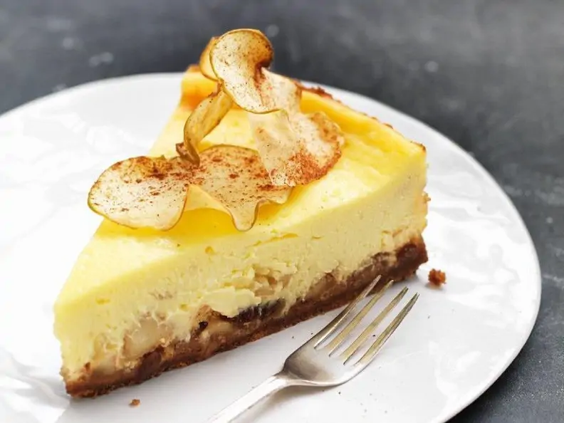 Apfel-Käsekuchen mit Keksboden auf grauem Grund