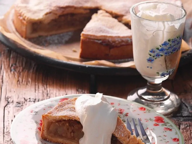 Gedeckter Apfelkuchen mit Sahne