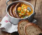 Bratwürste in Gemüsesuppe mit Kürbis, Kartoffeln und Sellerie