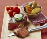 Steak mit Kräuterbutter, gebackenen Kartoffeln und Tomaten