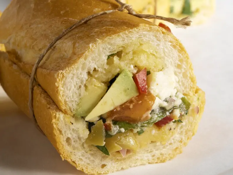 Baguettebrötchen mit Avocado, Schafskäse, Oliven und Paprika