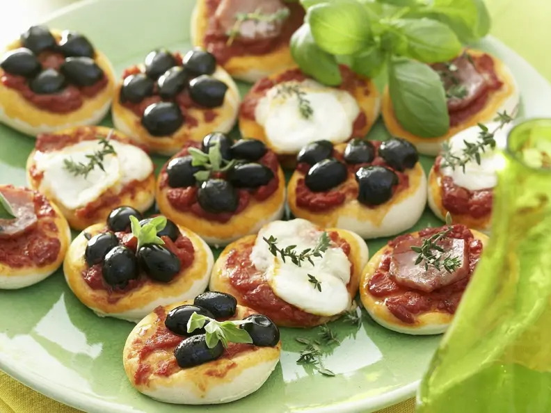Kleine Pizza-Happen mit Olive, Mozzarella und Schinken
