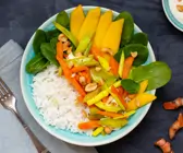Reisbowl mit Kurkumagemüse, Babyspinat, Erdnussdip und Mango