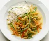 Hähnchenstreifen mit Gemüse und Kokossoße aus dem Wok, dazu Reis
