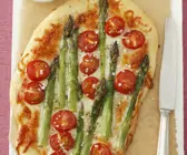 Pizza mit grünem Spargel und Cherrytomaten