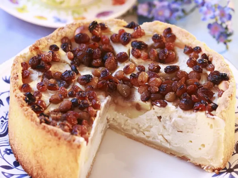 Apfel-Käsekuchen mit Rosinen auf geblümten Teller
