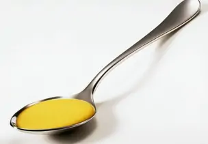 Gelbe Currysoße auf einem silbernen Löffel