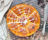 Halloween Kürbisbrötchen mit Spinnennetz auf dunklem Grund