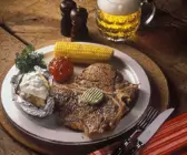 Steak mit Maiskolben, gegrillter Tomate und Ofenkartoffel