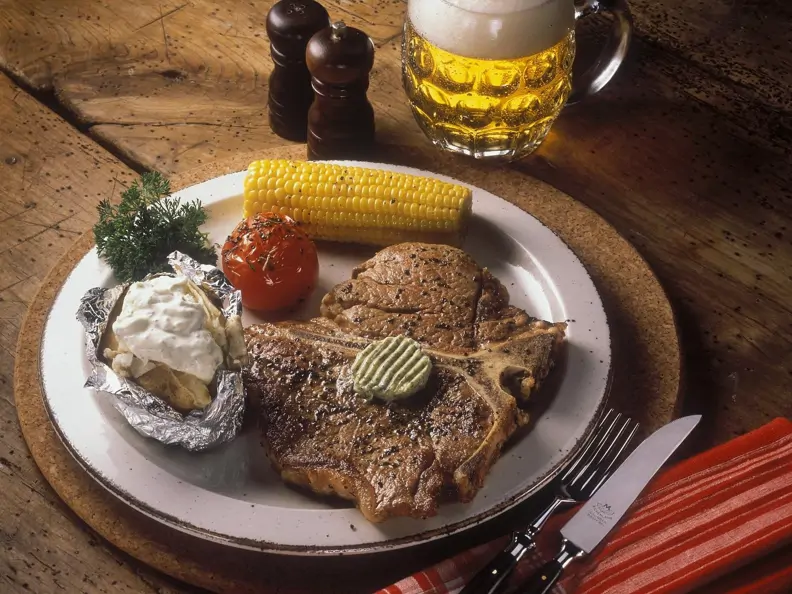 Steak mit Maiskolben, gegrillter Tomate und Ofenkartoffel