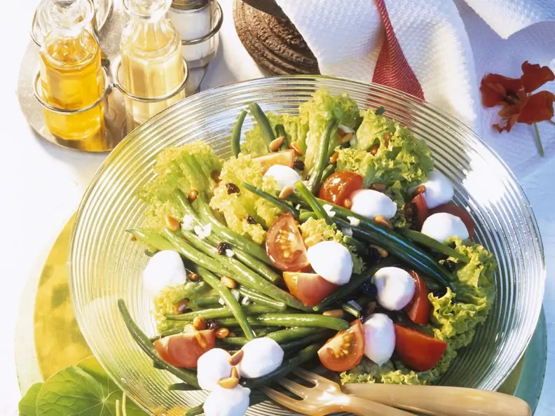 Salat mit grünen Bohnen, Mozzarella, Tomaten, Pinienkernen und Rosinen