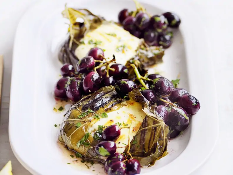 Weinblätter mit Mozzarellafüllung dazu Trauben und Anchovies
