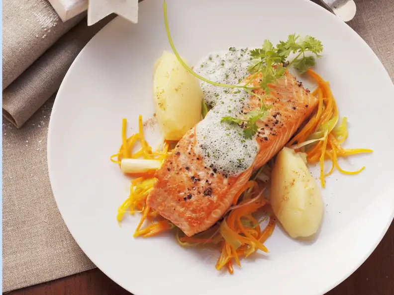 Lachsschnitte mit schaumiger Kräutersoße und Karottenstreifen