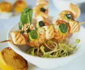 Spieße mit Shrimps, Lachs und Zucchini auf Sprossen