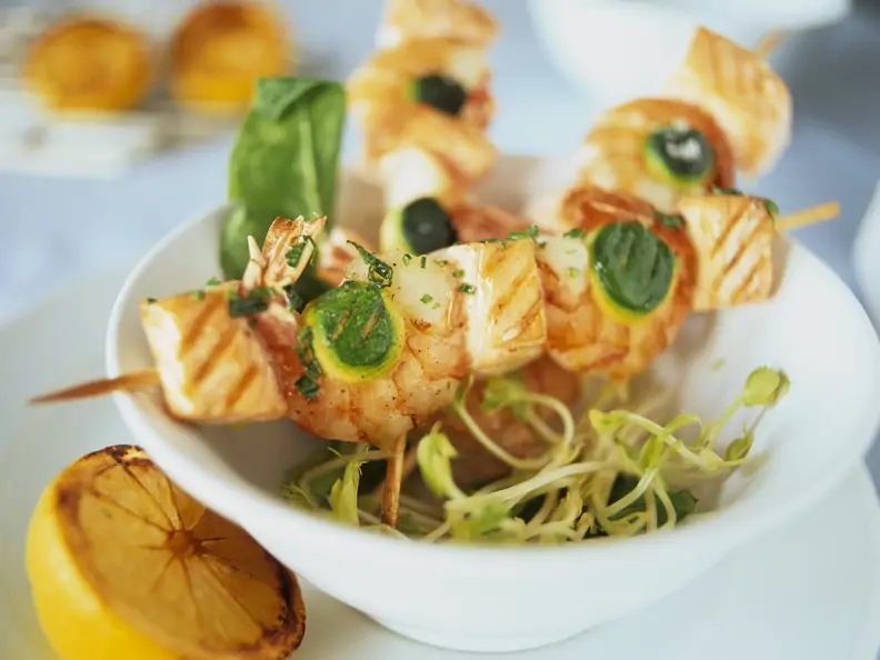 Spieße mit Shrimps, Lachs und Zucchini auf Sprossen