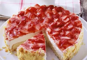 Angeschnittene Erdbeer-Quark-Torte mit gehobelten Mandeln