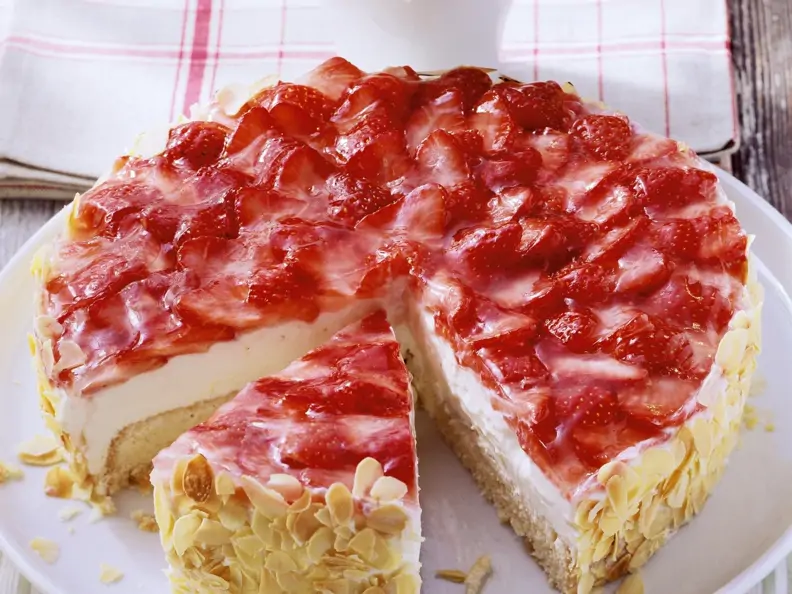 Angeschnittene Erdbeer-Quark-Torte mit gehobelten Mandeln