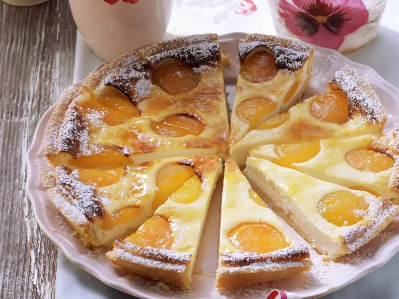 Klassischer Aprikosen-Käsekuchen auf rosafarbenem Teller