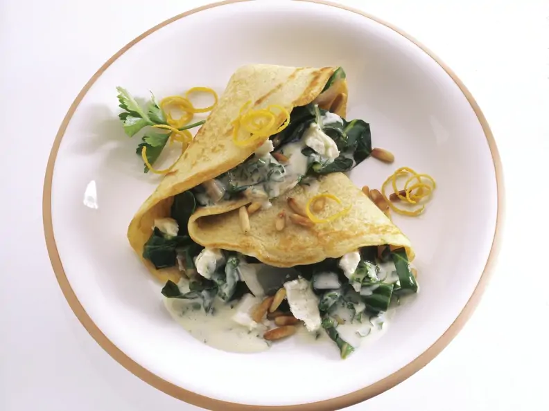 Pfannkuchen mit Mangold-Käse-Soße und Pinienkernen