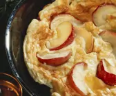 Pfannkuchen mit Apfelscheiben in einer Pfanne