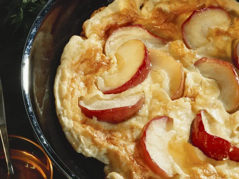 Pfannkuchen mit Apfelscheiben in einer Pfanne
