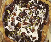 Süße Pizza mit Schokoladensoße und Nüssen