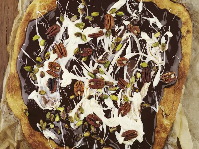 Süße Pizza mit Schokoladensoße und Nüssen