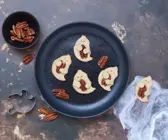 Keksgeister mit Pekannuss auf dunklem Grund
